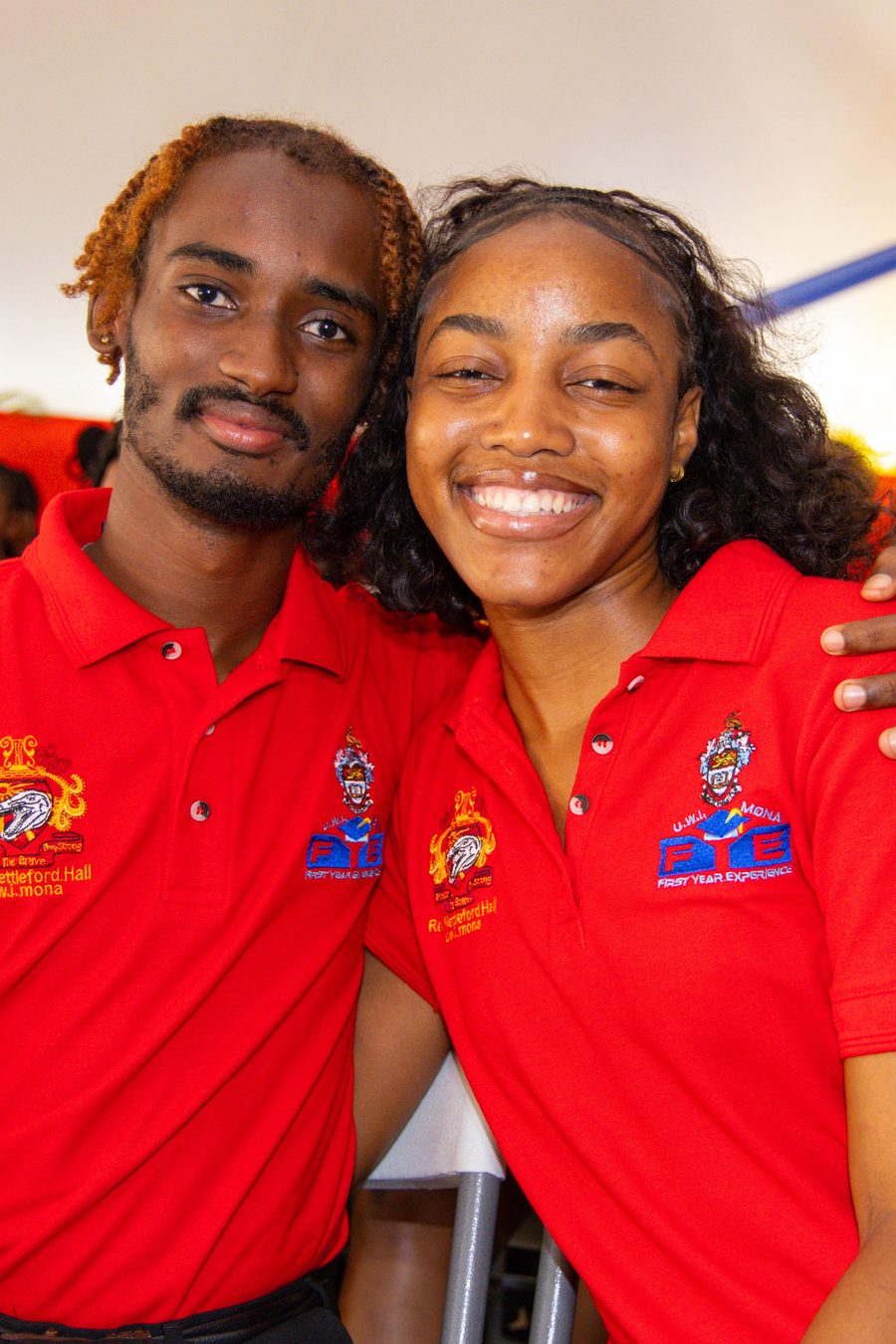 Two student ambassadors in red UWI polos, smiling