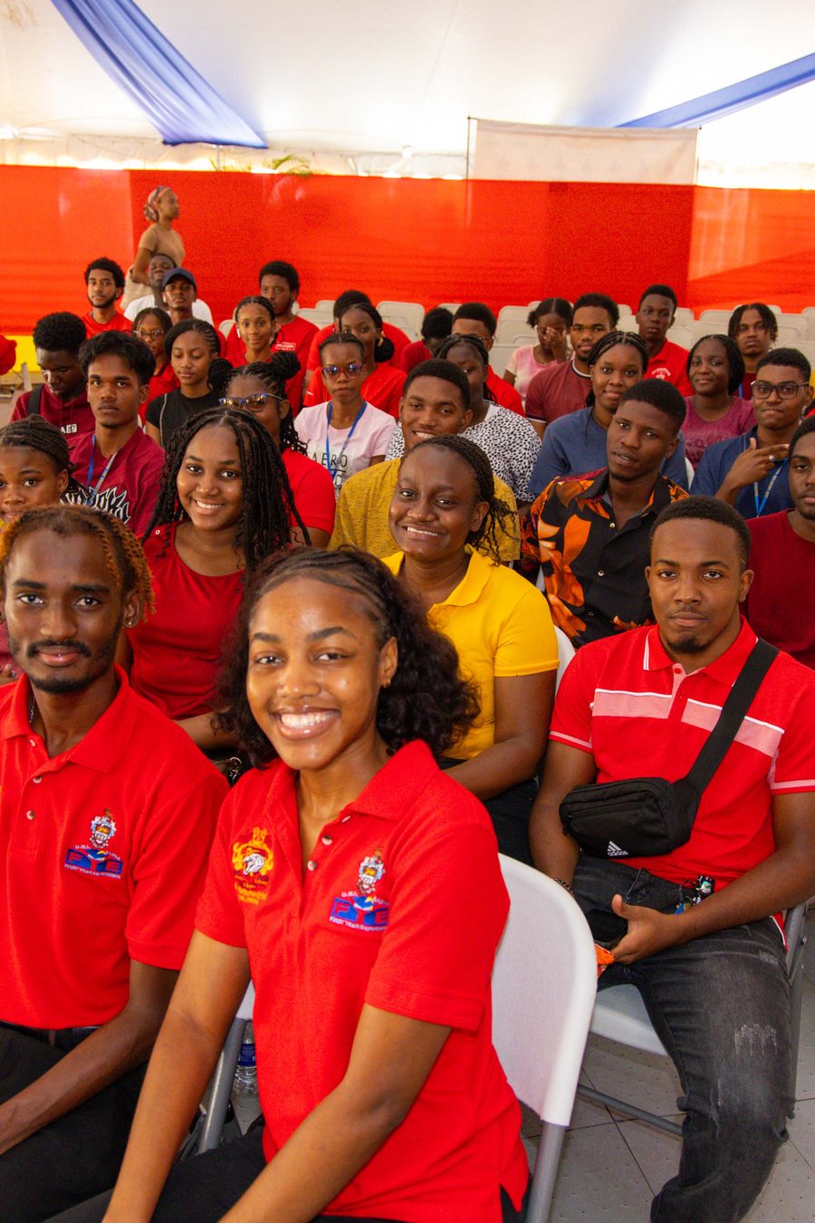 A row of students in red and yellow shirts, smiling at the camera